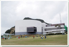 宇宙科学技術館とその前の公園で遊ぶ子供たち